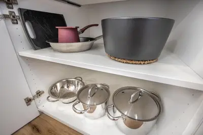 a bunch of pots and pans on shelves in a kitchen at Old Quarter Residence in Ljubljana