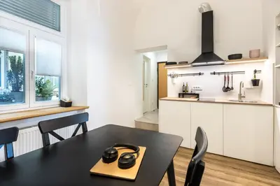 a kitchen and dining room with a black table and chairs at Old Quarter Residence in Ljubljana