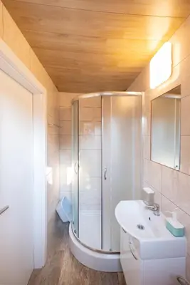 a bathroom with a shower and a white sink at Studio Southwest 3 with AirCon & FREE Parking in Ljubljana