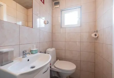 a bathroom with a sink and a toilet and a window at Studio Southwest 3 with AirCon & FREE Parking in Ljubljana