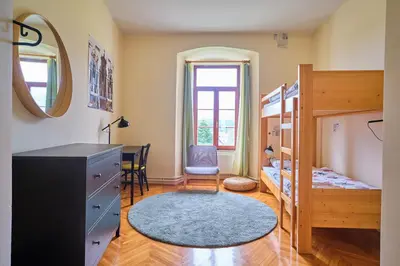 a bedroom with a bunk bed and a desk at Samostan Mekinje in Kamnik