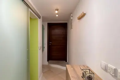 a hallway with green and white walls and a wooden door at Studio Sergio in Bled