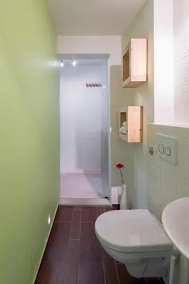 a bathroom with a toilet and two sinks and a shower at Studio Sergio in Bled