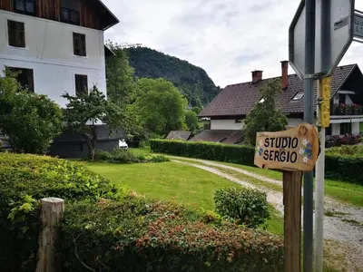 a stop sign in front of a yard with a house at Studio Sergio in Bled