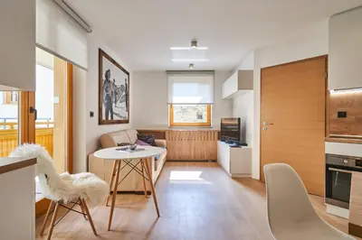 a kitchen and living room with a table and chairs at Cozy Apartment in the heart of Kranjska Gora in Kranjska Gora