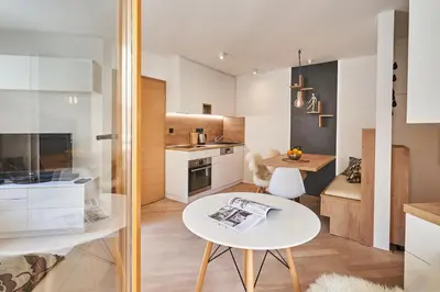 a small kitchen with a white table and a dining room at Cozy Apartment in the heart of Kranjska Gora in Kranjska Gora
