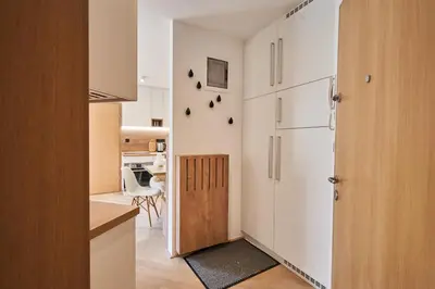 a kitchen with white cabinets and a door to a room at Cozy Apartment in the heart of Kranjska Gora in Kranjska Gora