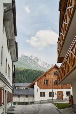a view of the mountains from between two buildings at Cozy Apartment in the heart of Kranjska Gora in Kranjska Gora