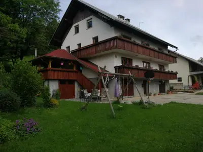 a large white house with a gambrel roof at Apatmaji Pika 2 in Cerklje na Gorenjskem