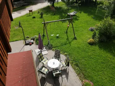 a patio with a table and chairs and a swing at Apatmaji Pika 2 in Cerklje na Gorenjskem