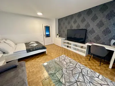 a living room with a bed and a flat screen tv at Clara Ljubljana Apartment in Ljubljana