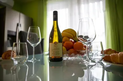 a bottle of wine sitting on a table with glasses at Clara Ljubljana Apartment in Ljubljana