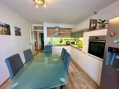 a kitchen with a green table and blue chairs at Clara Ljubljana Apartment in Ljubljana