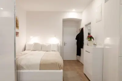 a white bedroom with a bed and a closet at Studio Apartment Gea Tour As Ljubljana in Ljubljana