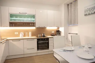 a kitchen with white cabinets and a white counter top at Studio Apartment Gea Tour As Ljubljana in Ljubljana