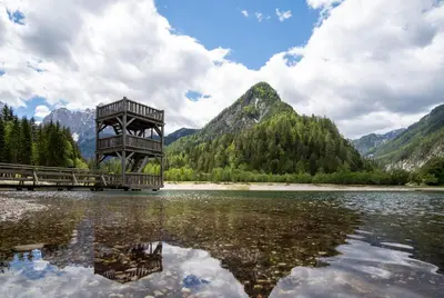 a wooden tower in the middle of a lake at Apartment Špica - Private parking in Kranjska Gora