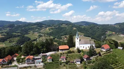 an aerial view of a small village with a church at Vineyard Paradise Senica in Dramlje