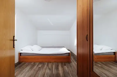 a small bedroom with a bed and a mirror at Vineyard Paradise Senica in Dramlje
