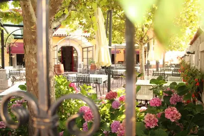 a patio with tables and chairs and flowers at Hotel Grahor Depandance in Sežana