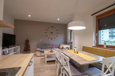 a kitchen and living room with a large clock on the wall at Bohinj - Old Village House in Bohinj
