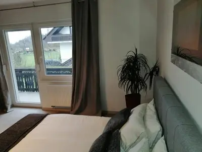 a bedroom with a couch and a large window at Kasita Bled Apartments in Bled