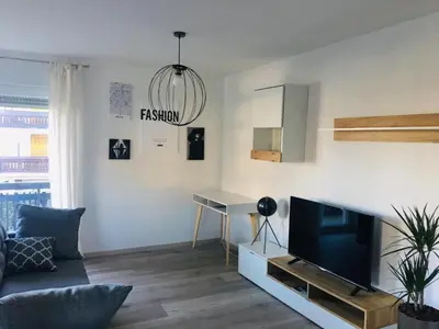 a living room with a couch and a tv and a desk at Kasita Bled Apartments in Bled