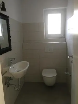 a bathroom with a sink and a toilet and a window at Kasita Bled Apartments in Bled
