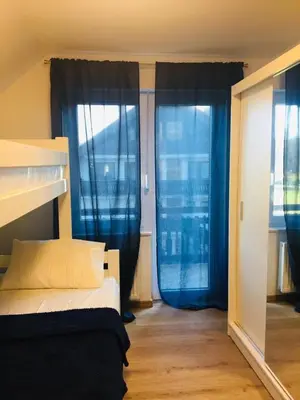 a bedroom with blue curtains and a bed and a window at Kasita Bled Apartments in Bled