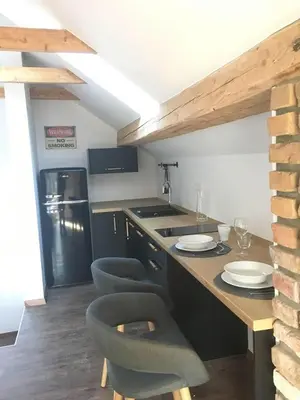 a kitchen with a counter with chairs and a refrigerator at Kasita Bled Apartments in Bled