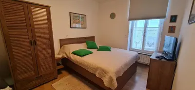 a bedroom with a bed with green pillows on it at APARTMA DOMENIKA in Ptuj