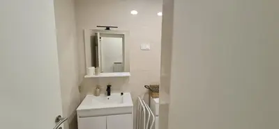 a white bathroom with a sink and a mirror at APARTMA DOMENIKA in Ptuj