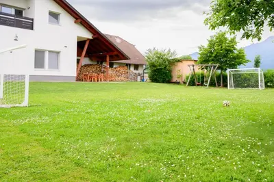 a dog in a yard with a soccer ball at APARTMA RANČ LUŽE in Kranj