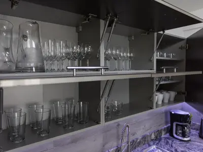 a row of glasses on a shelf in a kitchen at Reset Apartments in Kranjska Gora