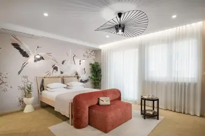 a bedroom with a large bed and a red chair at Eagle's Nest Ljubljana in Ljubljana