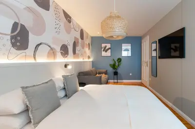 a bedroom with a large white bed and a couch at Eagle's Nest Ljubljana in Ljubljana
