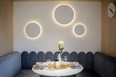 a dining room with a table and three circular mirrors at Eagle's Nest Ljubljana in Ljubljana