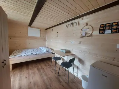 a room with a bed and two chairs and a table at Glamping Laze in Gorenja Vas