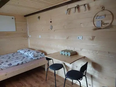 a room with a bed and a table and chairs at Glamping Laze in Gorenja Vas