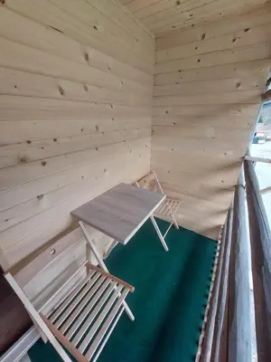 a wooden room with a table and chairs in it at Glamping Laze in Gorenja Vas