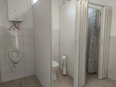 a bathroom with a urinal and a toilet in it at Glamping Laze in Gorenja Vas