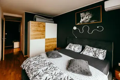 a bedroom with a bed with a black wall at HERMES APARTMENT & 2 free garage secured parkings in Ljubljana