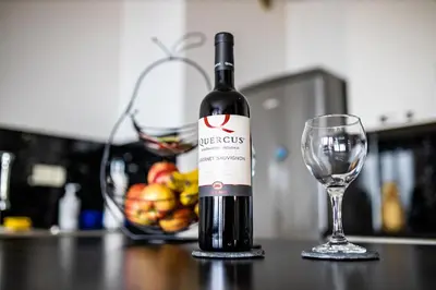 a bottle of wine sitting next to a wine glass at HERMES APARTMENT & 2 free garage secured parkings in Ljubljana