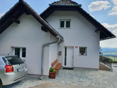 a white house with a car parked in front at Veronica's place in the mountains in Cerklje na Gorenjskem