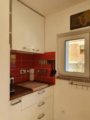 a kitchen with red and white cabinets and a window at Veronica's place in the mountains in Cerklje na Gorenjskem