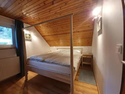 a bed in a room with a wooden ceiling at Veronica's place in the mountains in Cerklje na Gorenjskem
