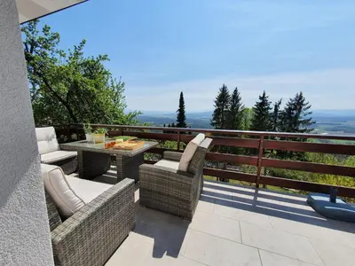 a patio with a table and chairs on a balcony at Veronica's place in the mountains in Cerklje na Gorenjskem