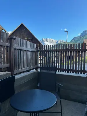 a table and chairs on a patio with a fence at Apartment Erlah in Rateče