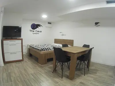 a room with a table and chairs and a bed at The Cave in Ljubljana