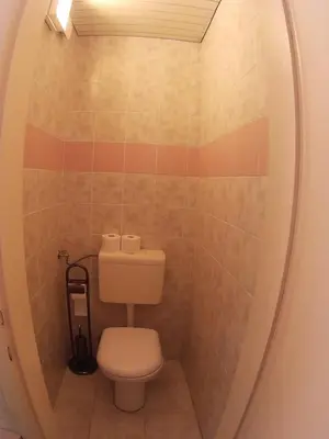 a bathroom with a toilet in a round mirror at The Cave in Ljubljana