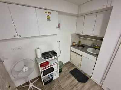 a small kitchen with white cabinets and a sink at The Cave in Ljubljana